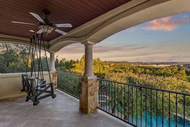 patio terrace at dusk with a balcony and ceiling fan