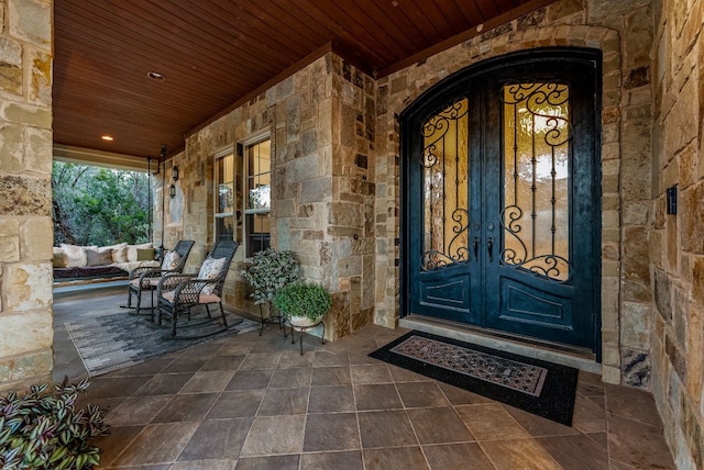 7409 Lantern View Dr, Jonestown, TX 78645 - doorway to property featuring stone siding, a porch, and french doors
