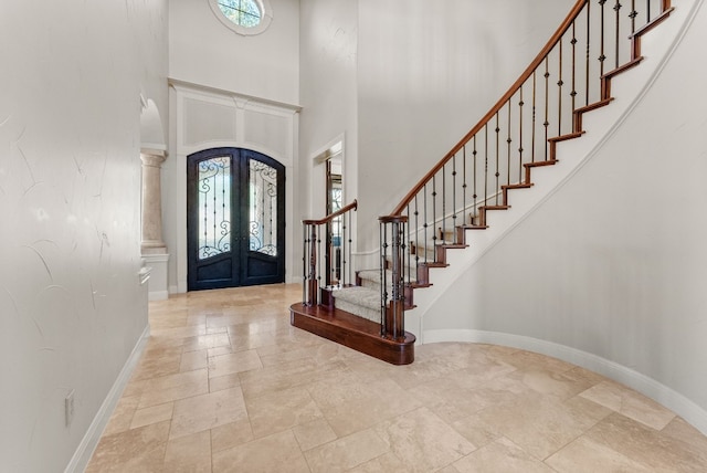 7409 Lantern View Dr, Jonestown, TX 78645 - foyer entrance with french doors, plenty of natural light, stone tile floors, a high ceiling, and stairs