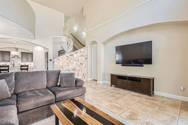 living room with light tile patterned flooring, sink, and high vaulted ceiling