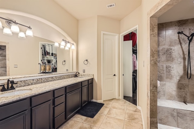 bathroom featuring tiled shower, vanity, and tile patterned floors