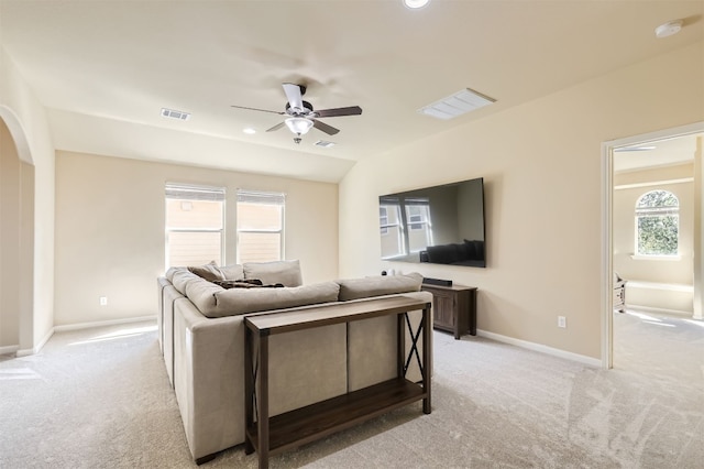 living room featuring ceiling fan, light colored carpet, and a healthy amount of sunlight