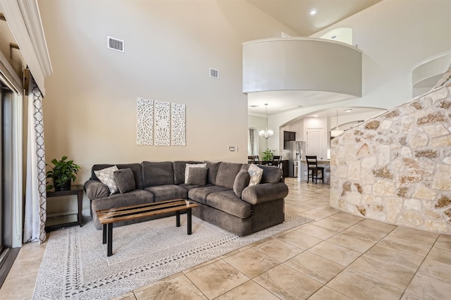 tiled living room with a chandelier and a towering ceiling