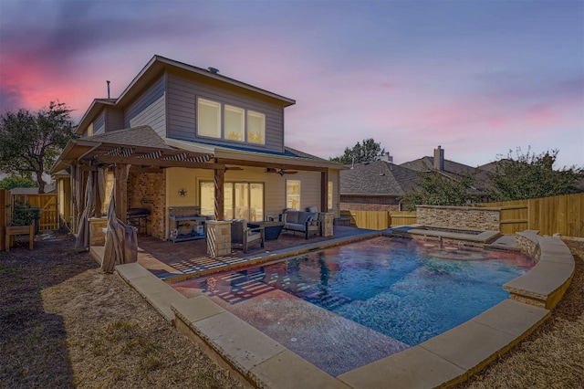 pool at dusk featuring an outdoor living space, a patio, and ceiling fan