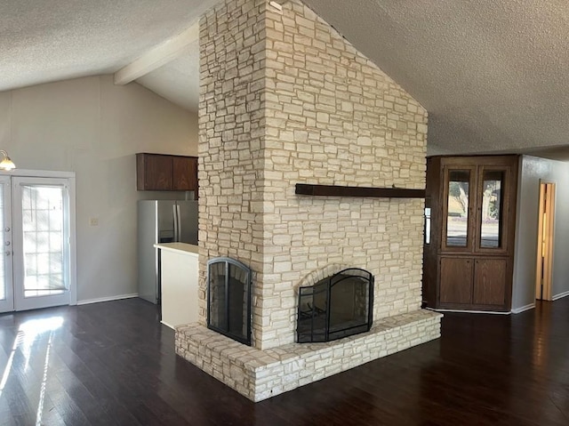 unfurnished living room with a textured ceiling, a fireplace, a healthy amount of sunlight, and dark wood-type flooring