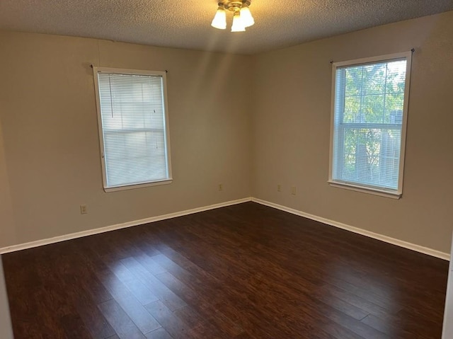 spare room featuring ceiling fan, a textured ceiling, and dark wood-type flooring