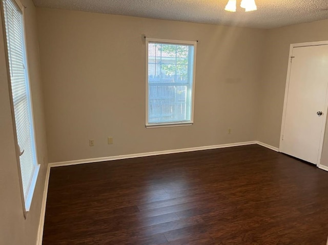 empty room featuring dark hardwood / wood-style flooring and a textured ceiling