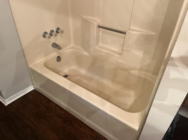 bathroom featuring washtub / shower combination and hardwood / wood-style flooring