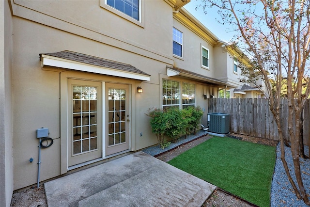 property entrance with a yard and cooling unit