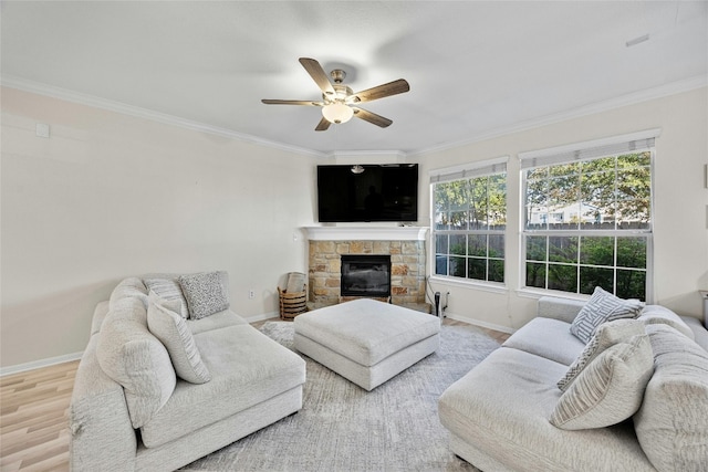 living room featuring hardwood / wood-style flooring, a stone fireplace, and crown molding