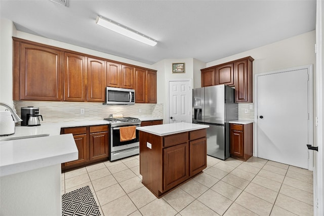 kitchen with tasteful backsplash, stainless steel appliances, light tile patterned floors, sink, and a center island