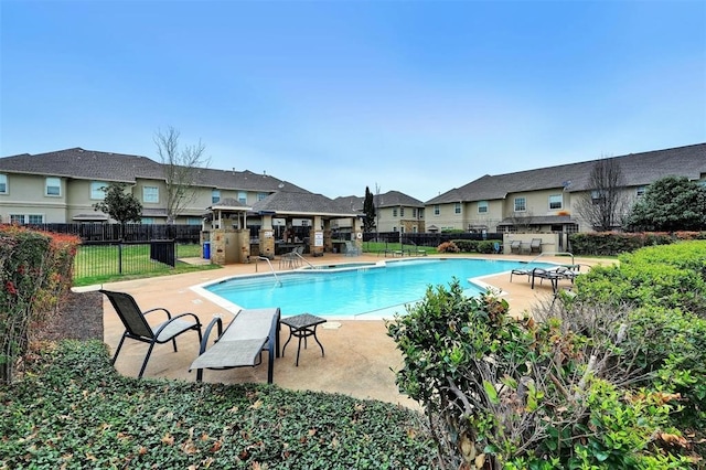 view of swimming pool with an outdoor kitchen and a patio