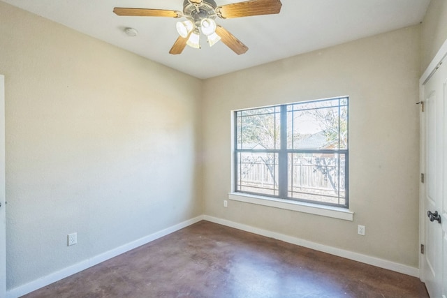 unfurnished room with ceiling fan and concrete floors