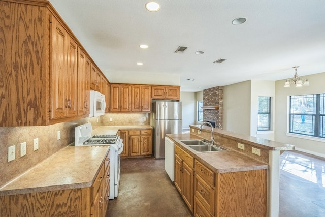 kitchen featuring white appliances, sink, decorative backsplash, a chandelier, and a kitchen island with sink