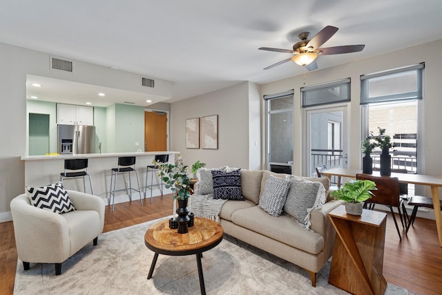 living room with ceiling fan and light wood-type flooring