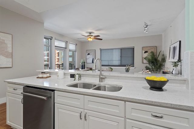 kitchen with hardwood / wood-style floors, light stone countertops, white cabinetry, and sink