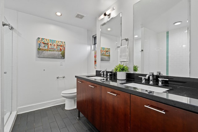 bathroom featuring vanity, toilet, and tiled shower