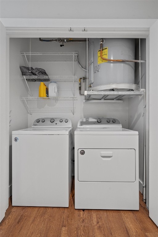 laundry room with washing machine and clothes dryer and light wood-type flooring