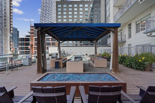 view of patio featuring outdoor lounge area, a wooden deck, and a gazebo