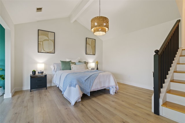 bedroom featuring light hardwood / wood-style flooring and vaulted ceiling with beams