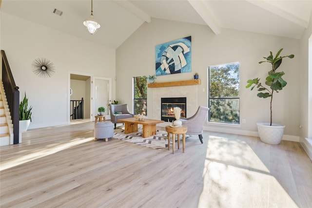 living room featuring light hardwood / wood-style flooring, beam ceiling, and high vaulted ceiling