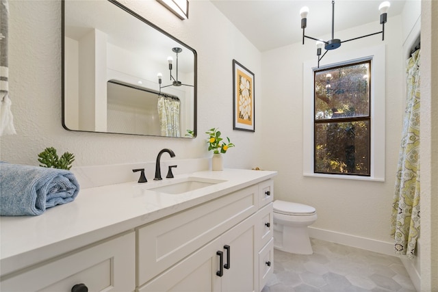 bathroom with tile patterned flooring, vanity, a chandelier, and toilet