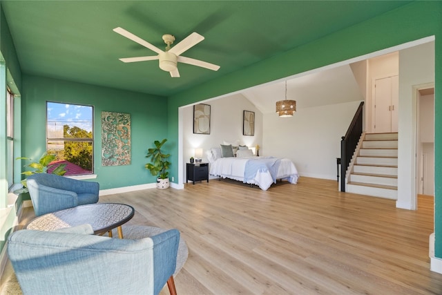 bedroom featuring light hardwood / wood-style floors, vaulted ceiling, and ceiling fan