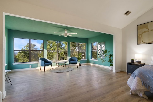 bedroom featuring vaulted ceiling, ceiling fan, multiple windows, and light hardwood / wood-style floors