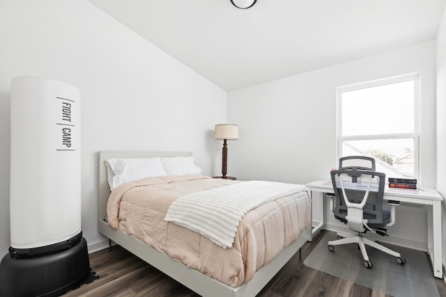 bedroom featuring lofted ceiling, baseboards, and dark wood-style flooring