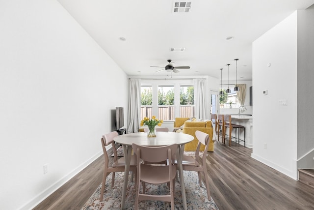 dining room featuring baseboards, visible vents, and dark wood-style flooring