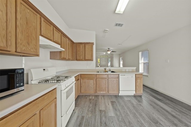 kitchen with sink, white appliances, ceiling fan, kitchen peninsula, and light wood-type flooring