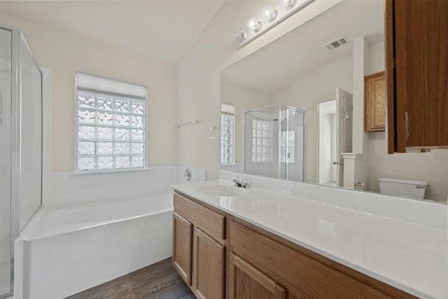 full bathroom with vanity, wood-type flooring, shower with separate bathtub, and toilet