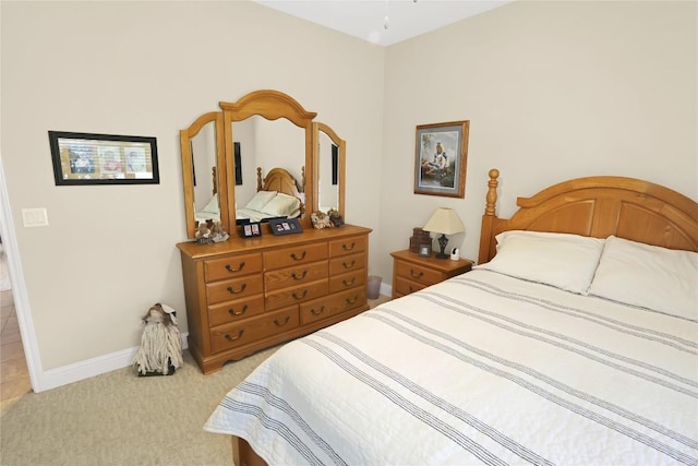 bedroom with baseboards and light carpet