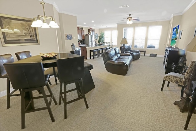 dining space featuring visible vents, baseboards, light colored carpet, and ornamental molding