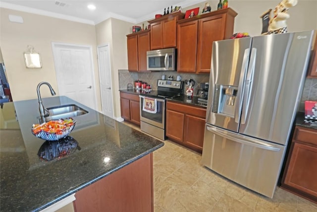 kitchen featuring dark stone counters, ornamental molding, decorative backsplash, stainless steel appliances, and a sink