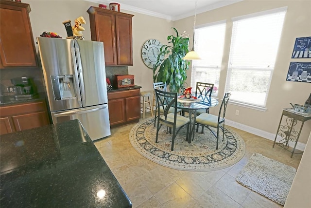 kitchen featuring crown molding, baseboards, dark stone counters, decorative backsplash, and stainless steel refrigerator with ice dispenser