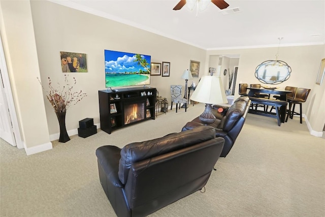 carpeted living area featuring a glass covered fireplace, crown molding, and baseboards