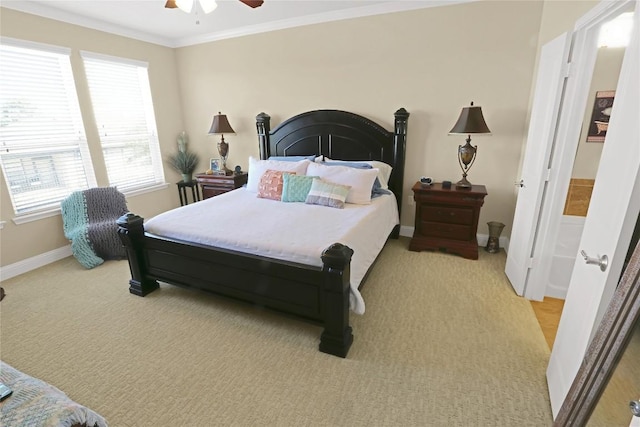 bedroom featuring baseboards, a ceiling fan, light carpet, and crown molding