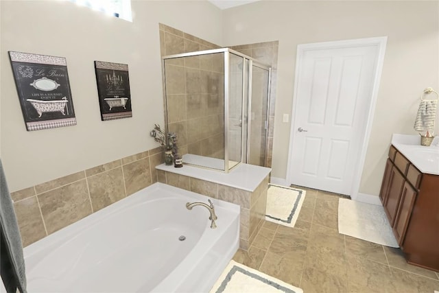 bathroom with a stall shower, vanity, and a bath