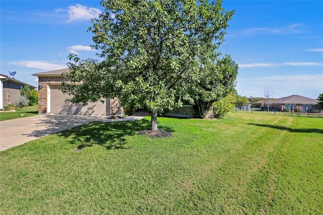 view of front facade featuring a front yard, fence, driveway, a garage, and brick siding