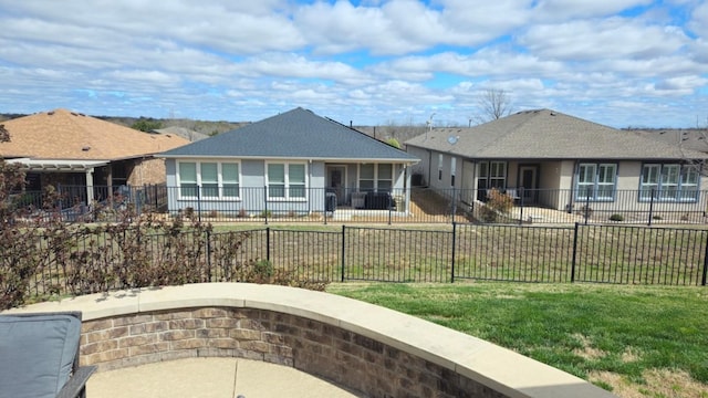 view of front facade with a front lawn, a residential view, a fenced front yard, and stucco siding