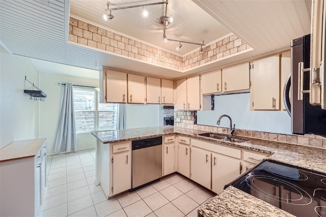 kitchen featuring sink, cream cabinets, rail lighting, kitchen peninsula, and stainless steel appliances