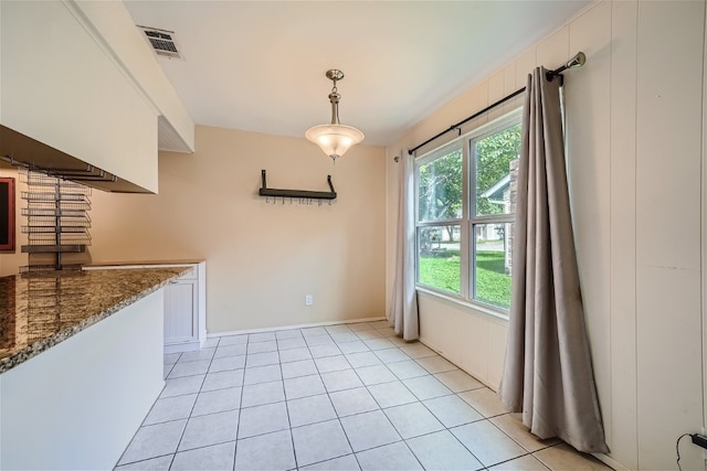 unfurnished dining area featuring light tile patterned floors