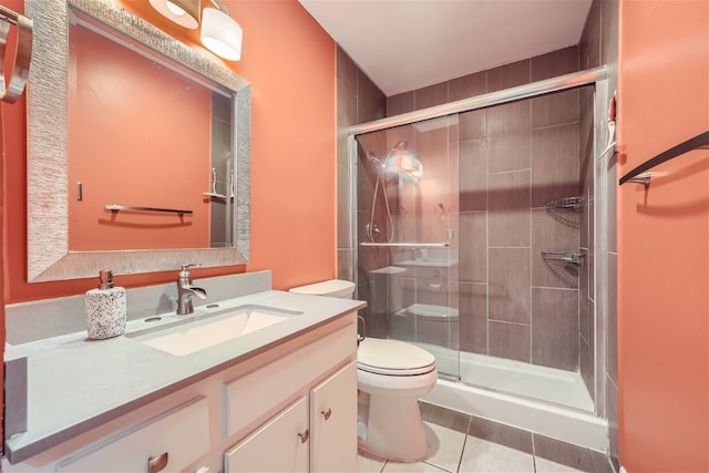 bathroom featuring tile patterned flooring, vanity, toilet, and a shower with shower door