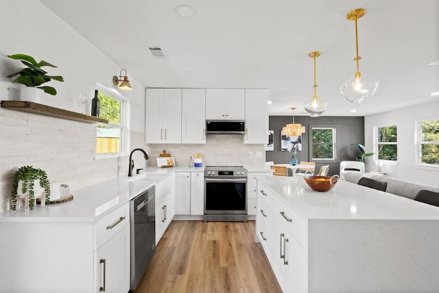 kitchen featuring white cabinetry, hanging light fixtures, a healthy amount of sunlight, and stainless steel appliances