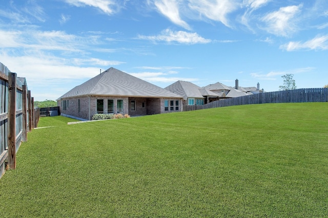 rear view of house featuring a lawn