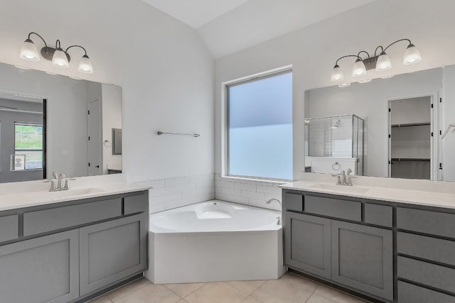 bathroom with vanity, vaulted ceiling, independent shower and bath, and tile patterned floors