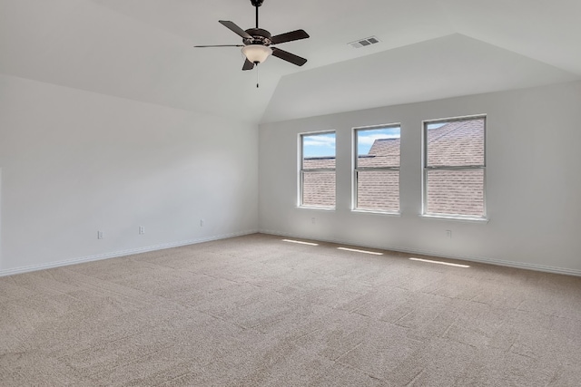 spare room with light carpet, ceiling fan, and vaulted ceiling