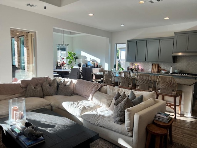 living room featuring visible vents, recessed lighting, and dark wood-style flooring