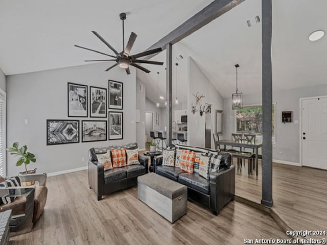 living room featuring beamed ceiling, light hardwood / wood-style flooring, high vaulted ceiling, and ceiling fan with notable chandelier